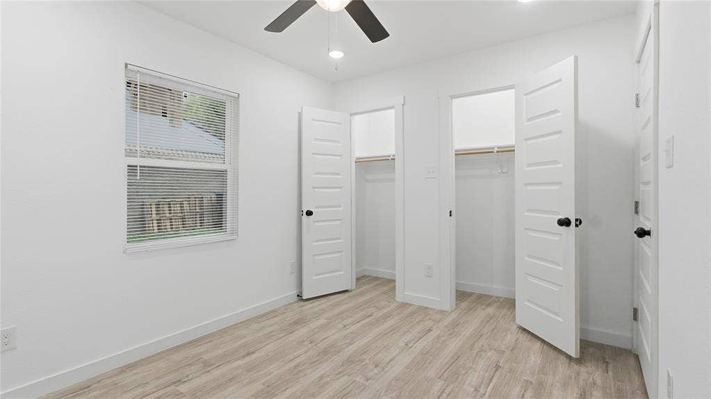 4330 Scottsdale Drive, Mesquite, TX 75150 Wood-finish flooring, dual-door closets, paneled doors with matte black hardware, and ceiling fan with integrated lighting