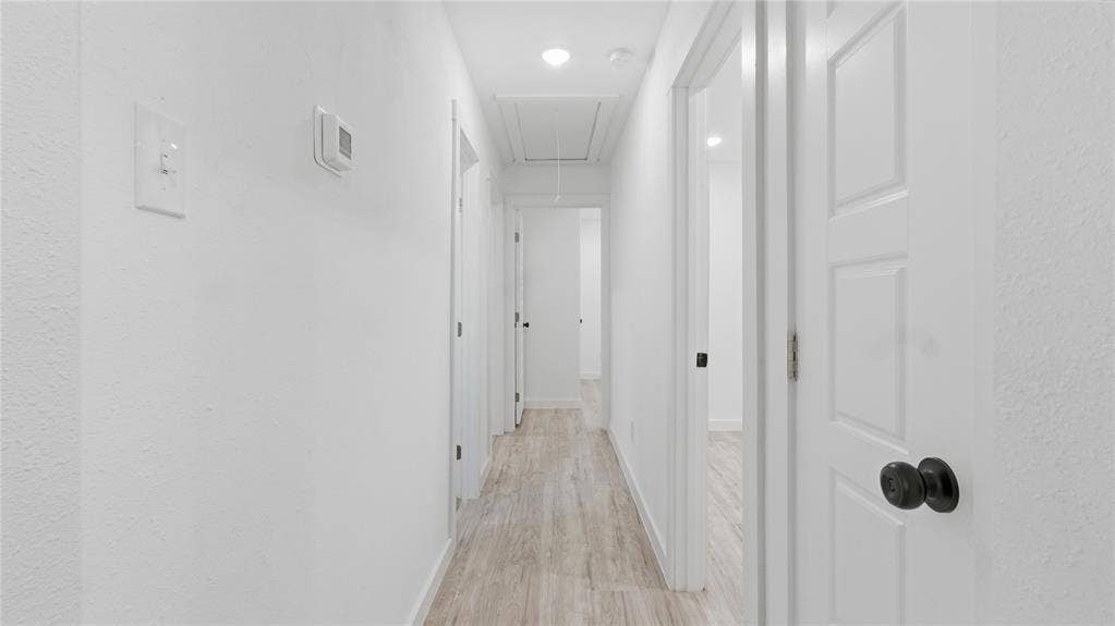 4330 Scottsdale Drive, Mesquite, TX 75150 Hallway featuring wood-finish flooring, recessed lighting, and multi-panel interior doors with matte black hardware