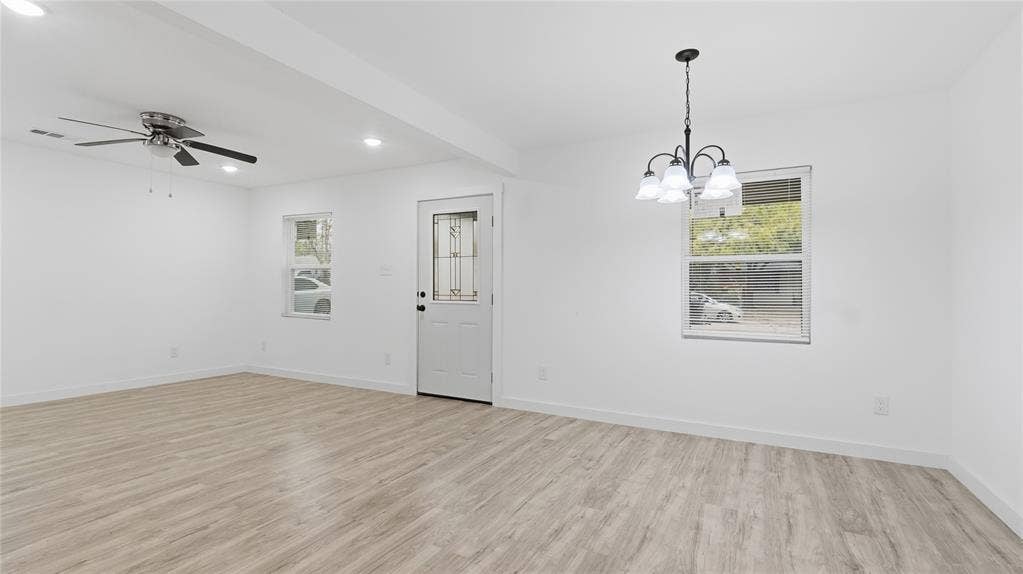 4330 Scottsdale Drive, Mesquite, TX 75150 Open-concept interior featuring wood-finish flooring, a five-light chandelier, a ceiling fan with integrated lighting, and an exterior door with leaded glass inlay
