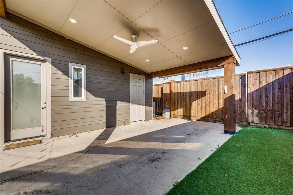 Covered patio featuring recessed lighting, a ceiling fan, horizontal siding, and synthetic turf lawn