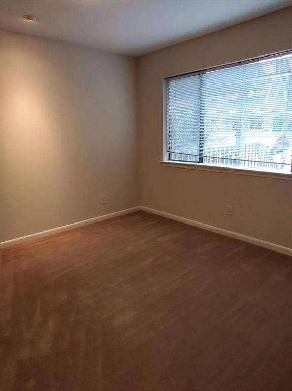 Neutral wall tones, wood-finish flooring, recessed lighting, and a large window with horizontal blinds