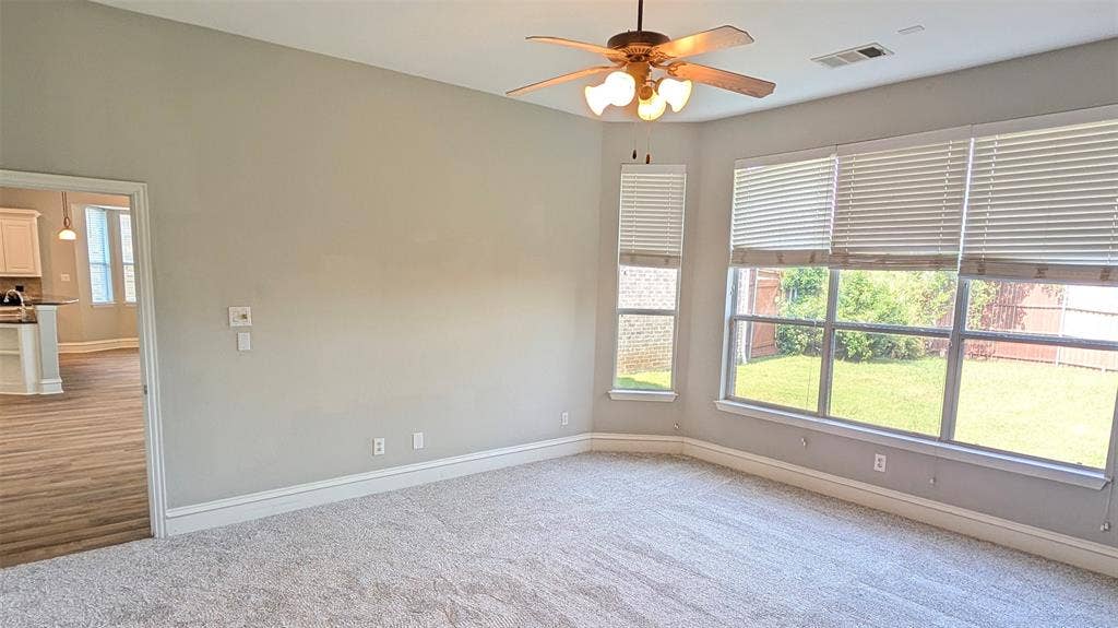 4221 Crestfield Drive, Richardson, TX 75082 High ceilings featuring a multi-light ceiling fan, expansive windows with horizontal blinds, and neutral carpeting