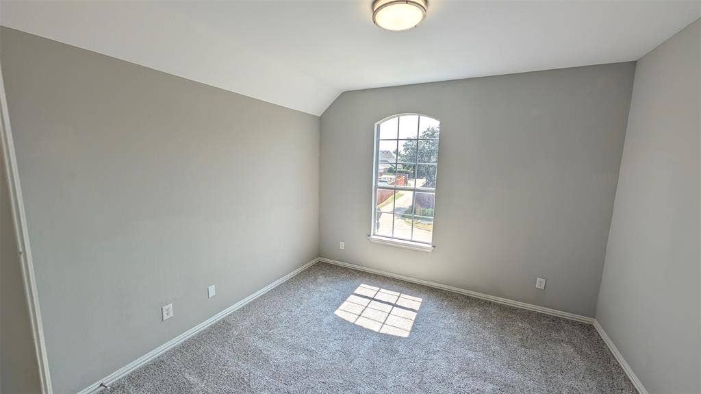 4221 Crestfield Drive, Richardson, TX 75082 Neutral-toned interior space featuring carpeting, an arched multi-pane window, and a flush-mount light fixture