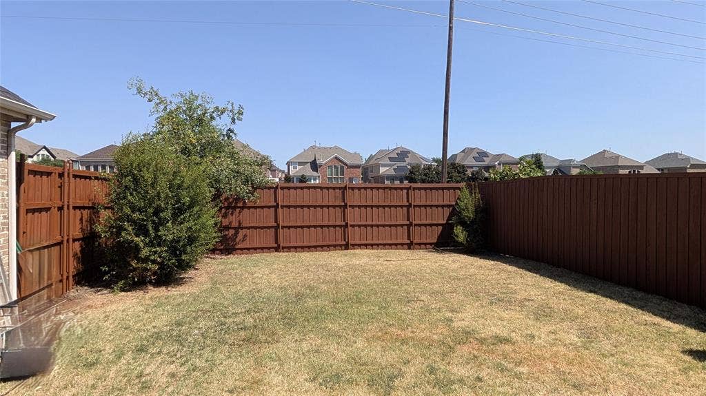 4221 Crestfield Drive, Richardson, TX 75082 Rear yard featuring a grass lawn and full-height wood fencing