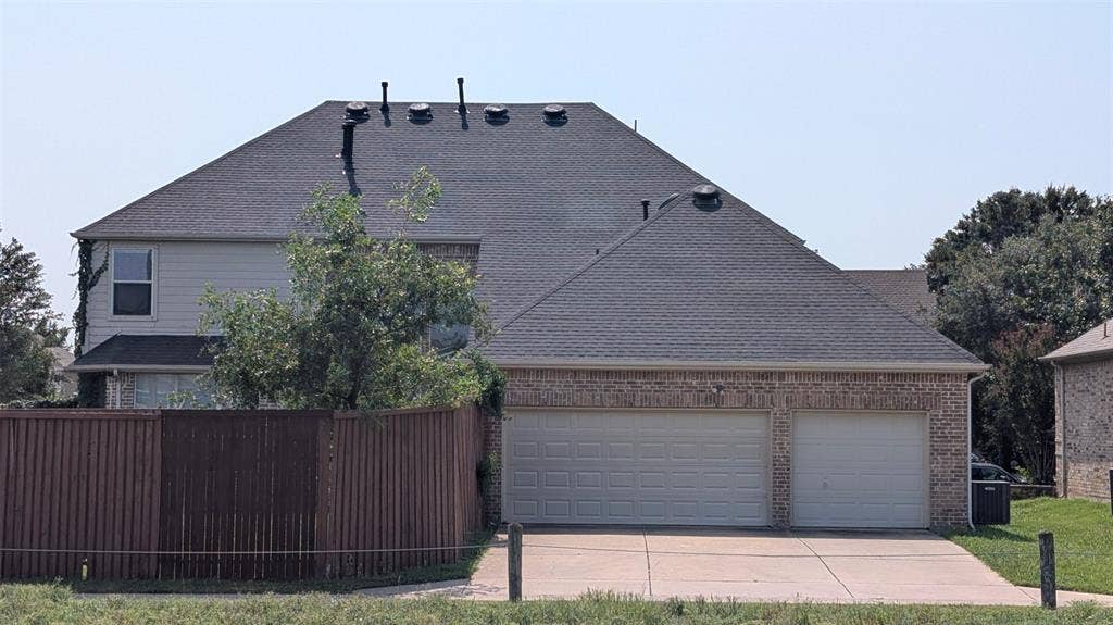 4221 Crestfield Drive, Richardson, TX 75082 Exterior elevation featuring a brick and siding facade, asphalt shingle roof, two-car garage, and concrete driveway