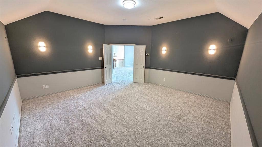 4221 Crestfield Drive, Richardson, TX 75082 Vaulted ceiling, wall-to-wall carpeting, two-toned wall paint, decorative chair rail, and four wall-mounted sconces