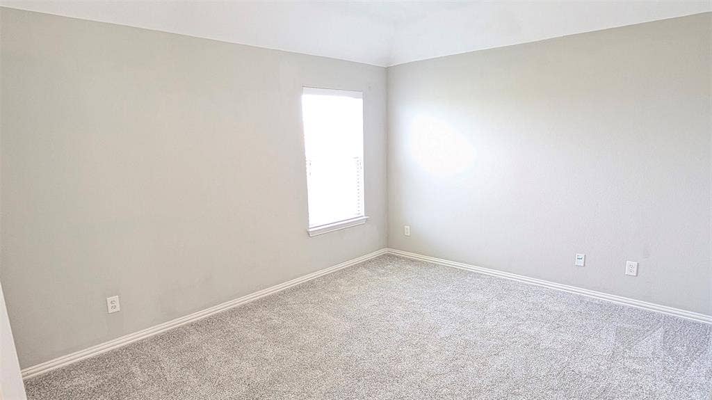 4221 Crestfield Drive, Richardson, TX 75082 Neutral-toned interior space featuring tray ceilings, neutral wall paint, and wall-to-wall carpeting
