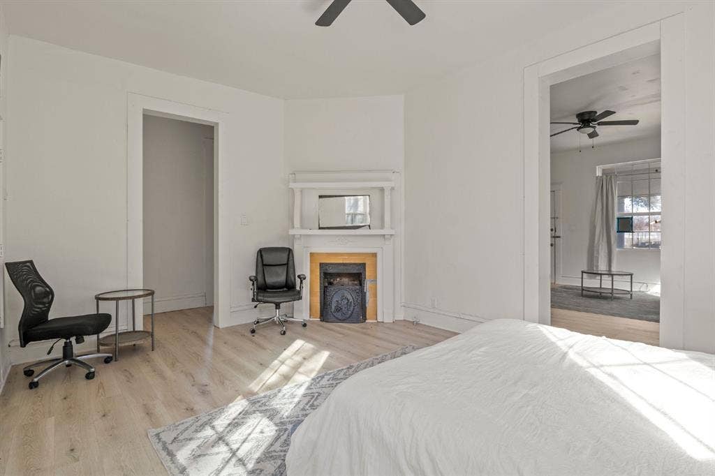 3711 Wendelkin Street, #1, Dallas, TX 75215 Interior space featuring wood-finish flooring, a corner fireplace with a mantel, and ceiling-mounted fans