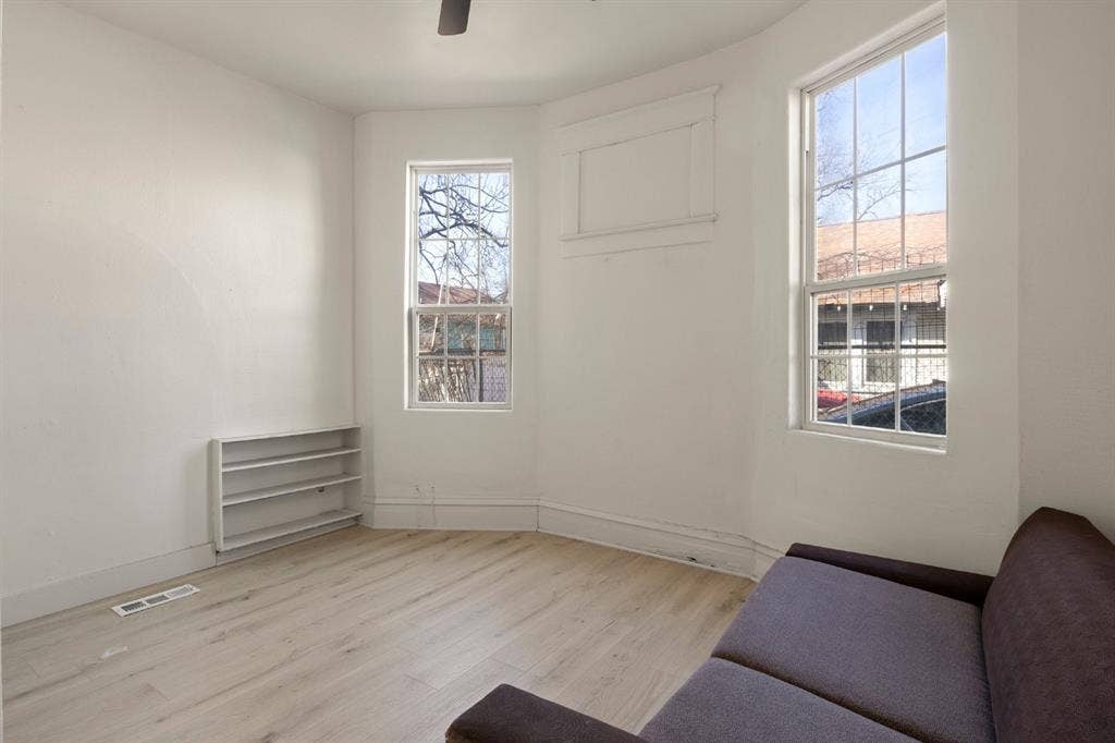 3711 Wendelkin Street, #1, Dallas, TX 75215 Bay window featuring multi-pane glass, wood-finish flooring, and built-in wall shelving