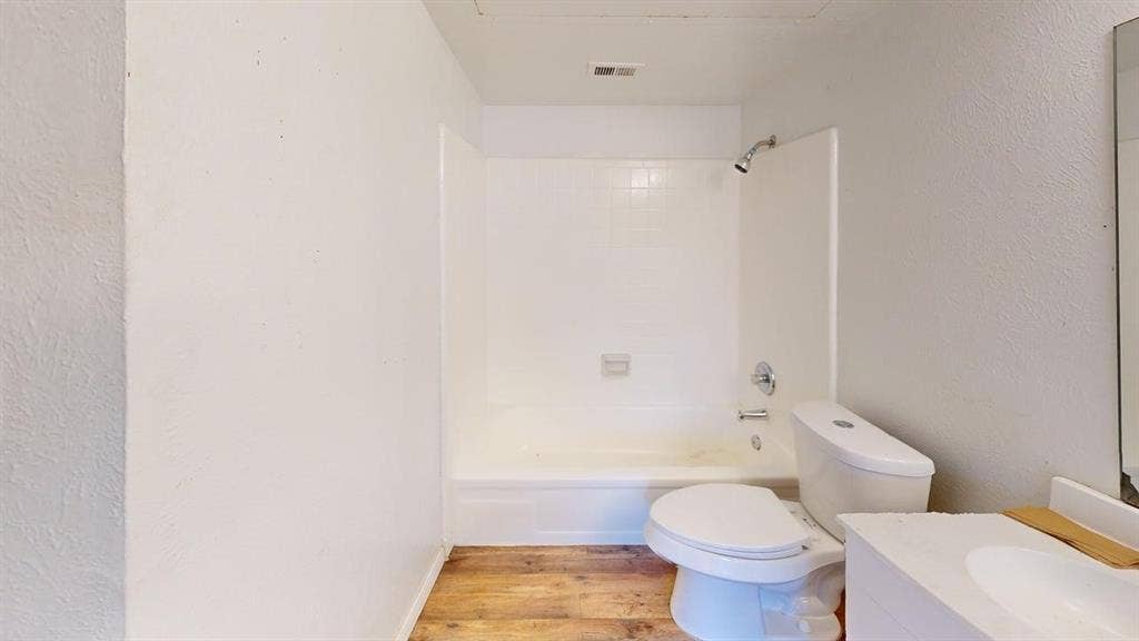 510 Matterhorn Street, Cedar Hill, TX 75104 Bathroom featuring wood-finish flooring, white tub-shower combination with tiled surround, and vanity with integrated basin