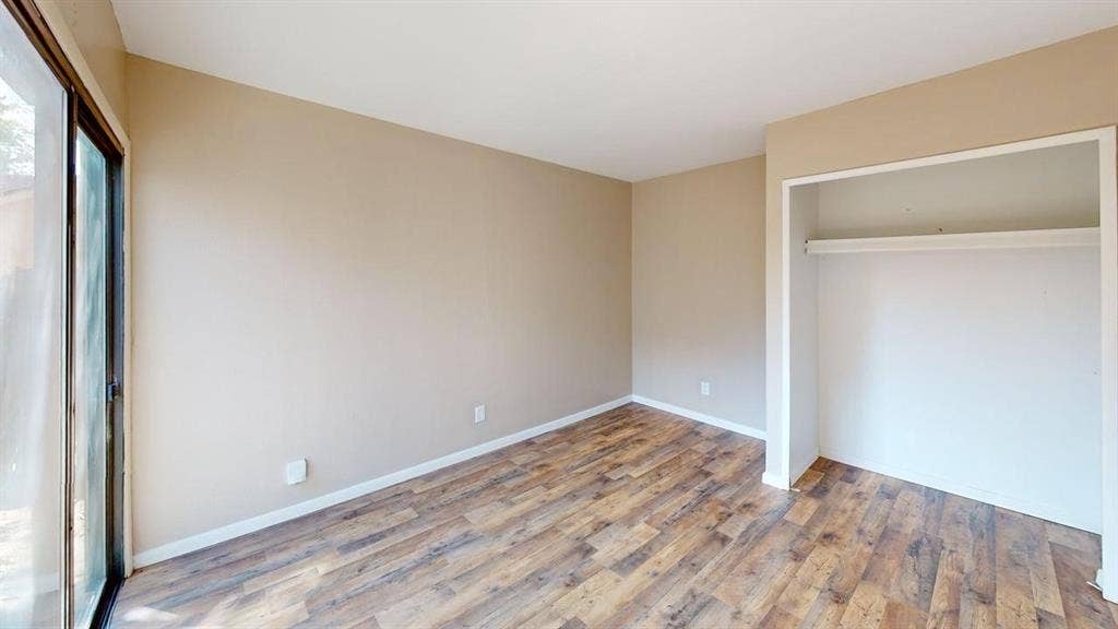 510 Matterhorn Street, Cedar Hill, TX 75104 Room featuring wood-finish flooring, neutral wall paint, and a sliding glass door providing exterior access, plus a built-in closet with an integrated shelf