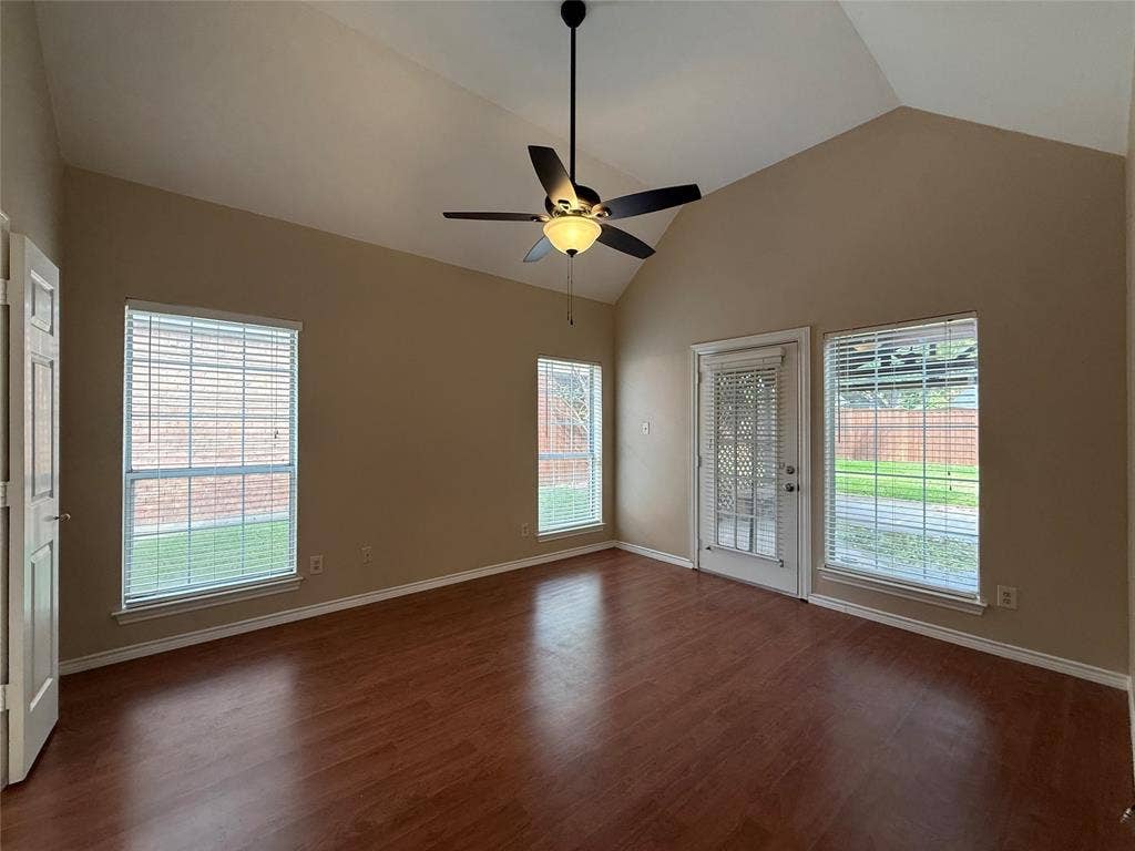 Vaulted ceilings, wood-finish flooring, multi-pane windows, and a central ceiling fan with integrated lighting