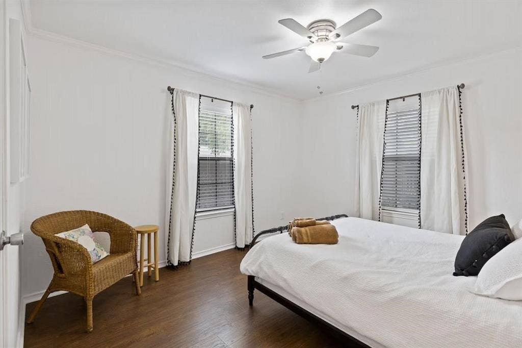 1101 N Waddill Street, McKinney, TX 75069 Bedroom featuring wood-finish flooring, dual windows with horizontal blinds, and a central ceiling fan with integrated lighting