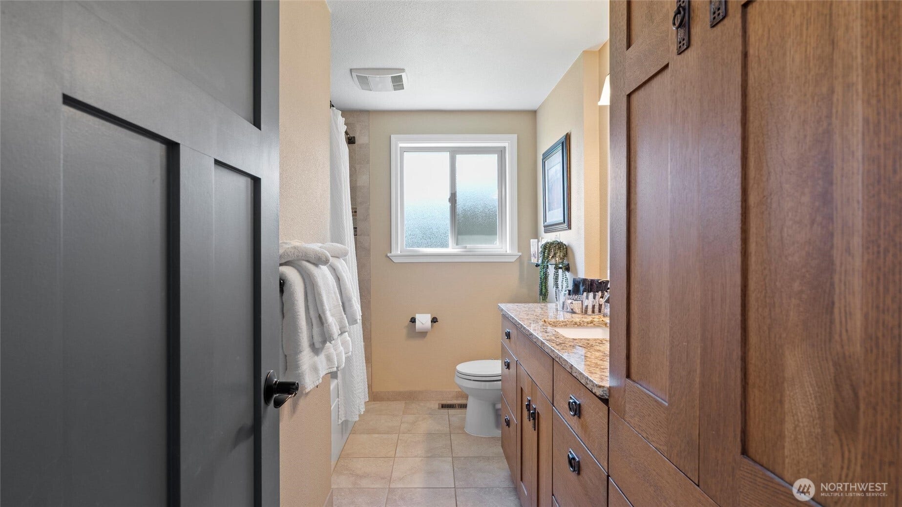 This full bath separates the primary from the second bedroom. Notice more of the beautiful cabinetry, including a floor-to-ceiling linen cabinet.