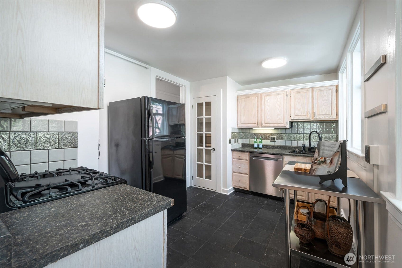 403 Terry Avenue, #206, Seattle, WA 98104 Bright kitchen with slate tile, gas range and glass doored pantry.