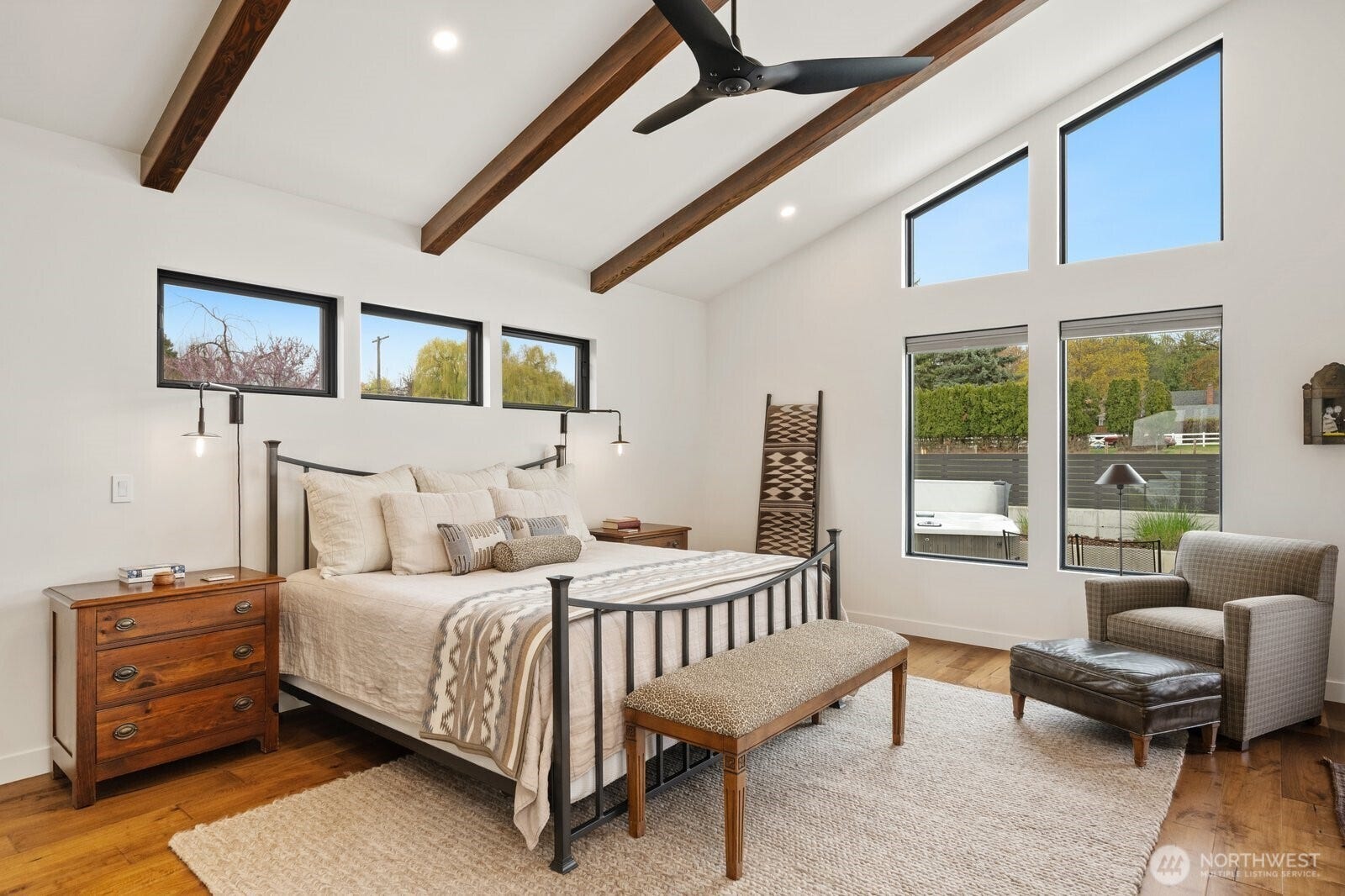 Primary suite with vaulted ceiling and windows to patio