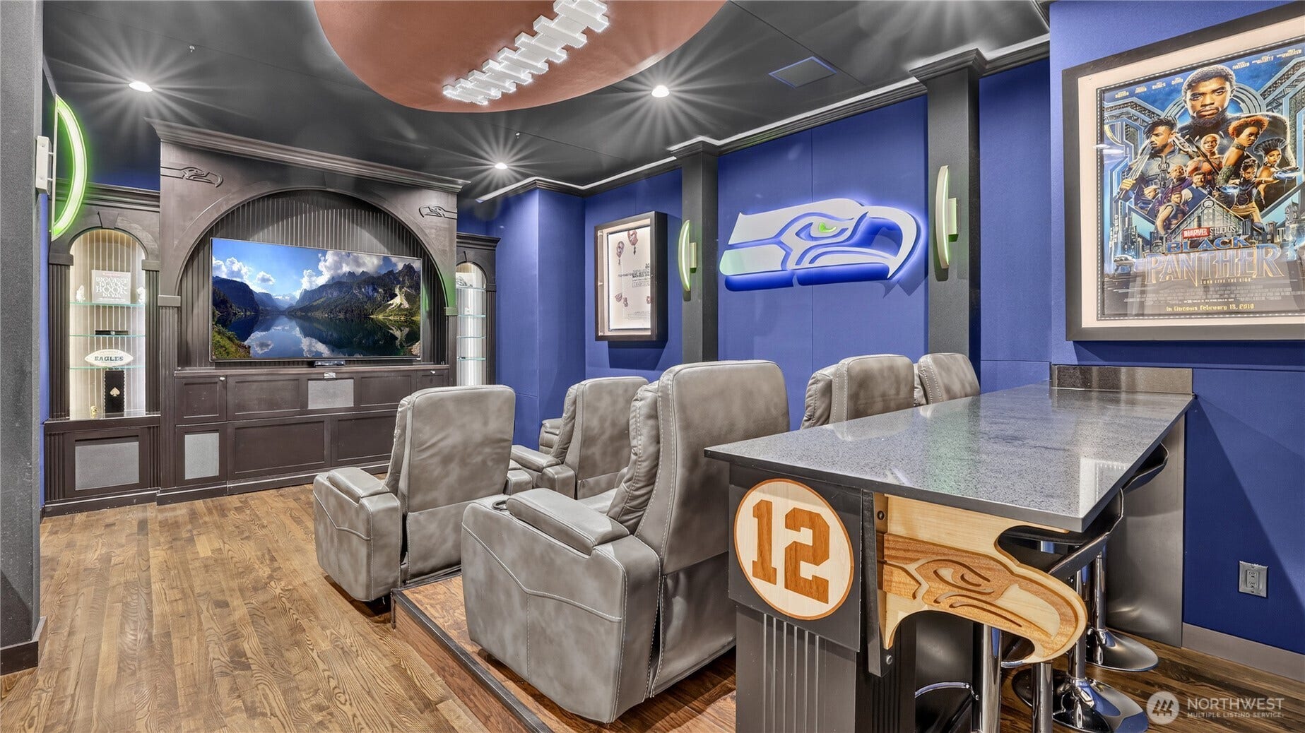 Immerse yourself in this custom Seahawks-themed theater  a striking blend of luxury and team spirit. Featuring tiered recliners, a large-format screen, and a sleek bar with signature 12 detailing, this space is ideal for movie nights or game days. The integrated Murphy bed adds versatility, allowing the room to function effortlessly as a comfortable fourth bedroom when needed. Every detail  from the football-themed ceiling feature to the integrated sound system and curated memorabilia niches  reflects elevated design and thoughtful functionality. A rare combination of luxury, comfort, and personality, this room delivers both entertainment and flexibility for modern living.