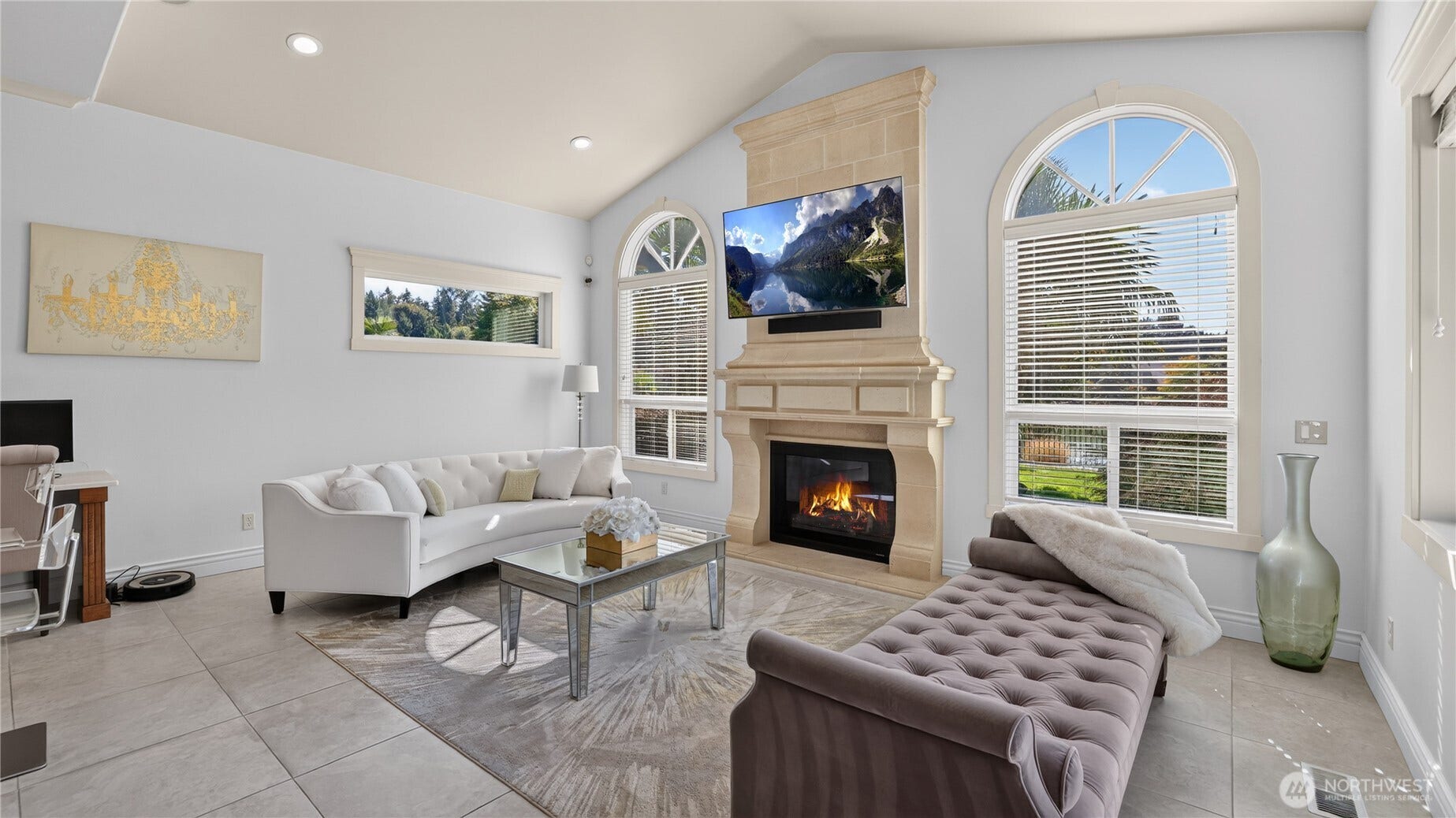 Family Room off Kitchen    This bright and welcoming family room offers a perfect blend of comfort and elegance. Featuring soaring ceilings, arched windows, and a stately stone fireplace, the space is filled with natural light and warmth. The open layout flows seamlessly from the kitchen, creating an ideal setting for entertaining or relaxing by the fire. Thoughtful design details and refined finishes make this room a centerpiece of the homes inviting atmosphere.