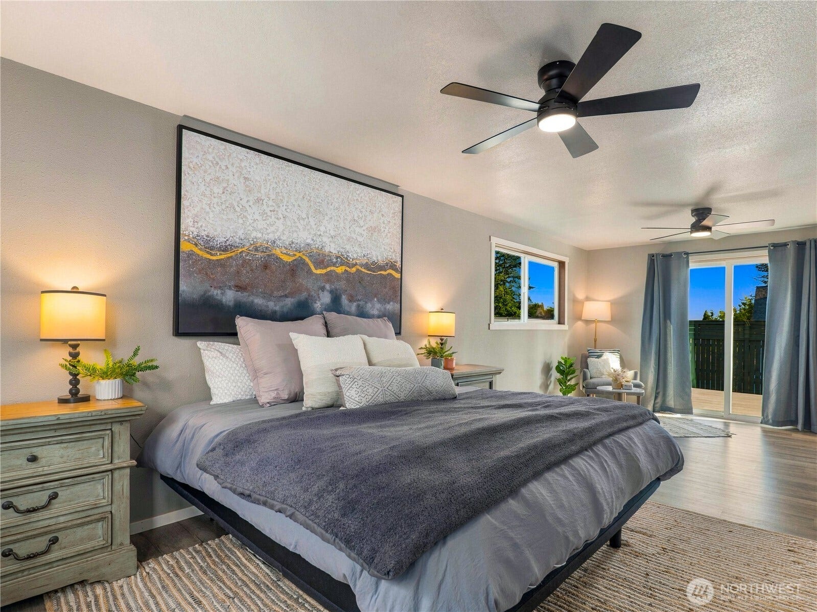1409 1st Street, Port Townsend, WA 98368 Spacious primary bedroom featuring dual closets, an updated ensuite bathroom, a cozy reading nook, and direct access to the Trex deck through a sliding glass door.