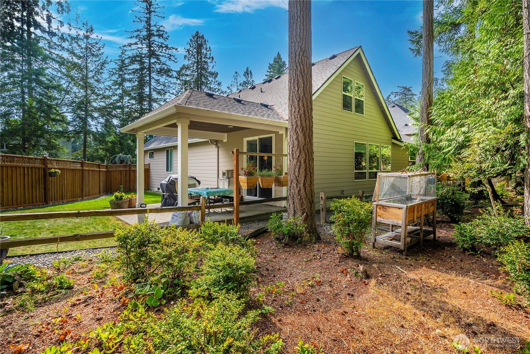 3413 Fox Court, Gig Harbor, WA 98335 Showing the covered patio from the greenbelt behind the home.