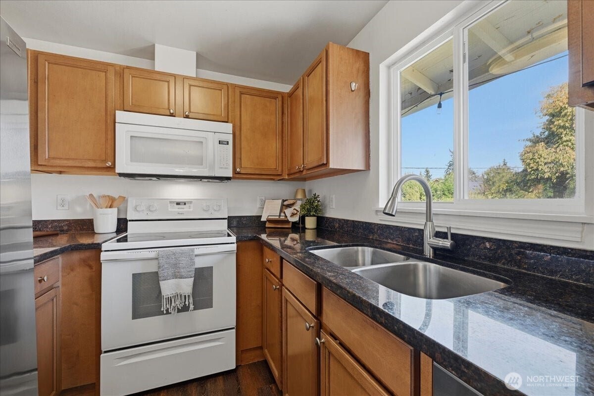 20807 3rd Avenue W, Lynnwood, WA 98036 Well-appointed kitchen featuring granite countertops, abundant cabinetry, a double-basin sink and a large window that fills the space with natural light