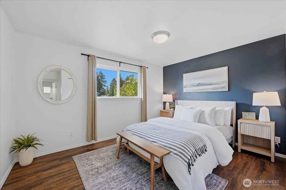 20807 3rd Avenue W, Lynnwood, WA 98036 Comfortable primary bedroom with warm LVP flooring, a stylish accent wall and a clean, inviting feel