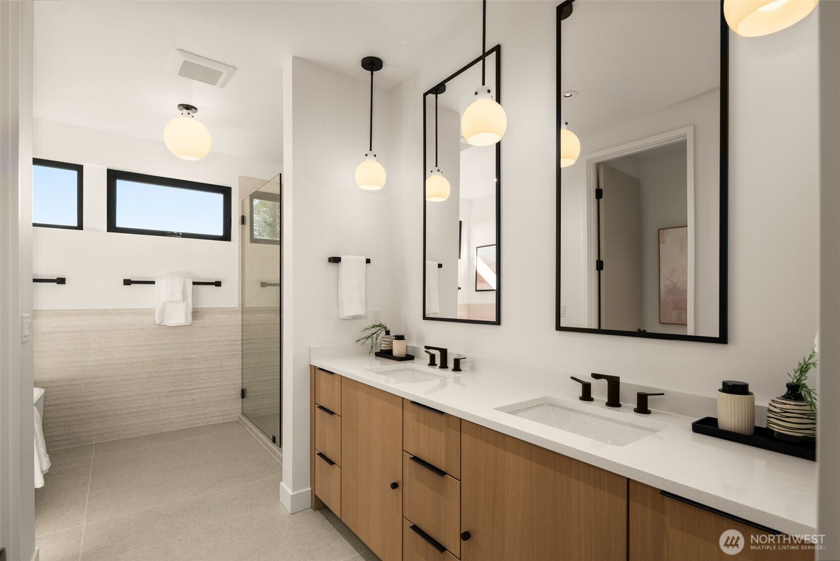 6021 Princeton Avenue NE, Seattle, WA 98115 The primary bathroom features large-format Porcelanosa tile, radiant heated floors, dual vanities, dramatic walk-in shower, and freestanding soaking tub.