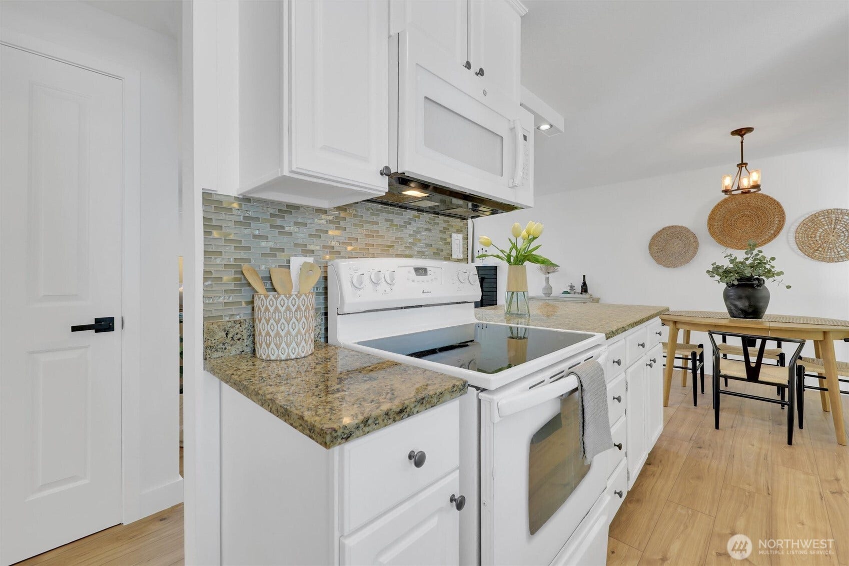 20915 W Richmond Road, Bothell, WA 98021 Bright kitchen featuring white cabinetry, granite countertops, electric range, tiled backsplash, and open access to the dining area.