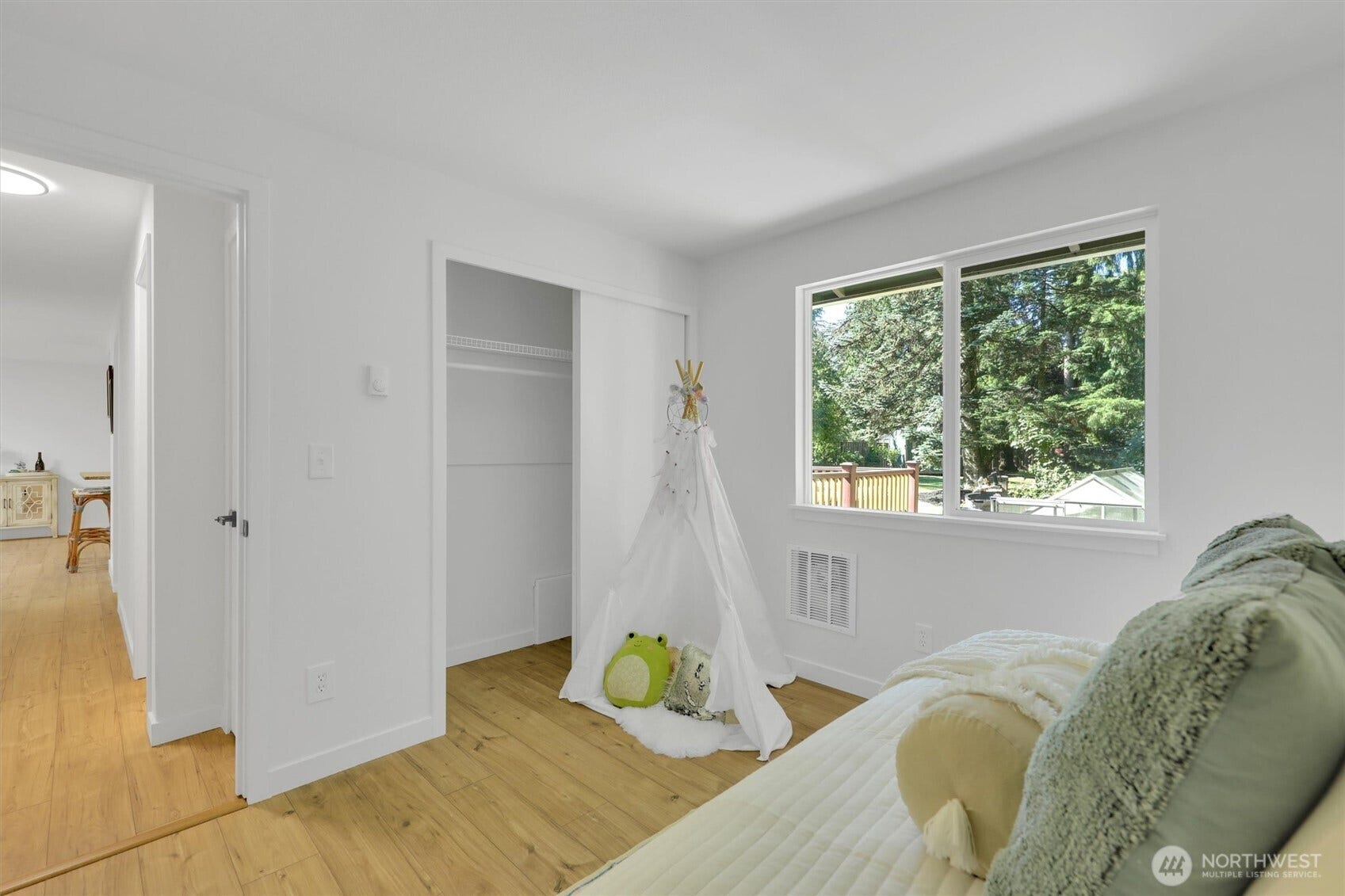 20915 W Richmond Road, Bothell, WA 98021 Bedroom with hardwood floors, large windows, neutral bedding, built-in closet area, and a cozy reading or seating space.