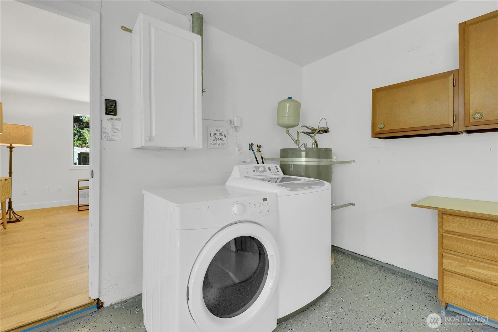 20915 W Richmond Road, Bothell, WA 98021 Laundry and utility area featuring a full-size washer and dryer, storage cabinets, countertop space, and durable flooring.
