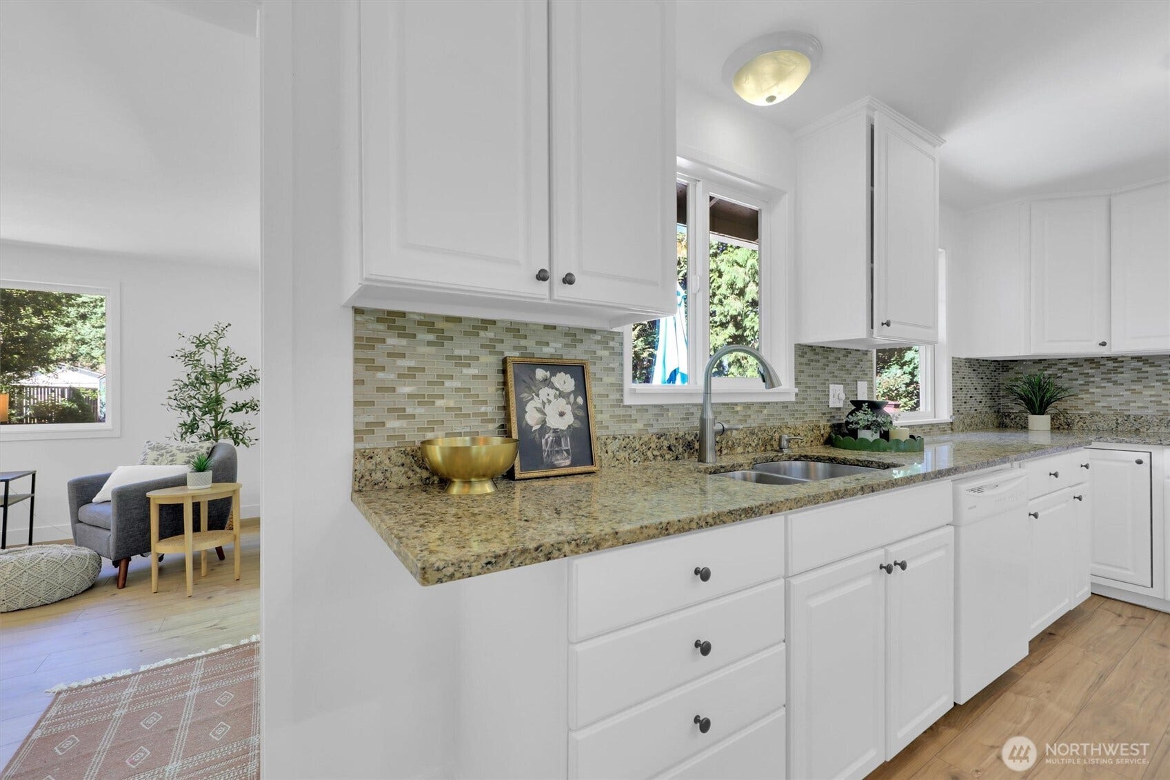20915 W Richmond Road, Bothell, WA 98021 Kitchen workspace featuring white cabinets, granite countertops, mosaic tile backsplash, hardwood floors, and a window providing natural light.