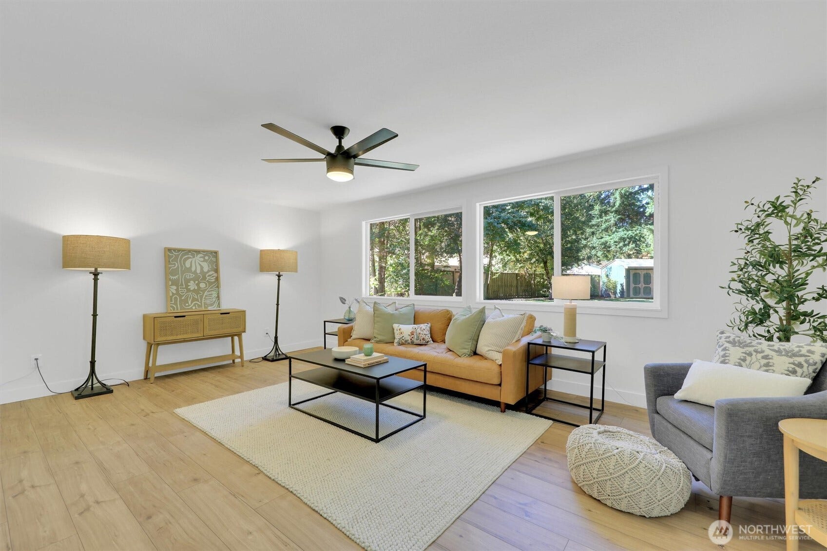 20915 W Richmond Road, Bothell, WA 98021 Spacious living room with hardwood floors, ceiling fan, large windows, comfortable seating, and abundant natural light.