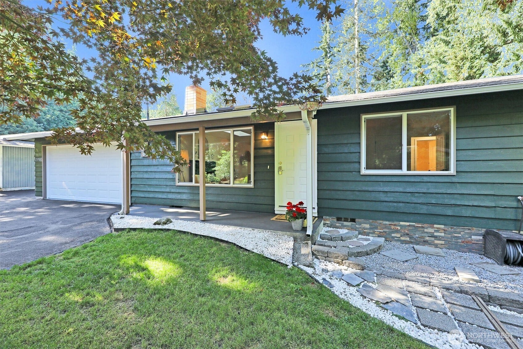 20915 W Richmond Road, Bothell, WA 98021 Exterior front view of 20915 W Richmond Rd in Bothell featuring the single-story home, attached garage, covered entry, landscaped yard, and mature trees.