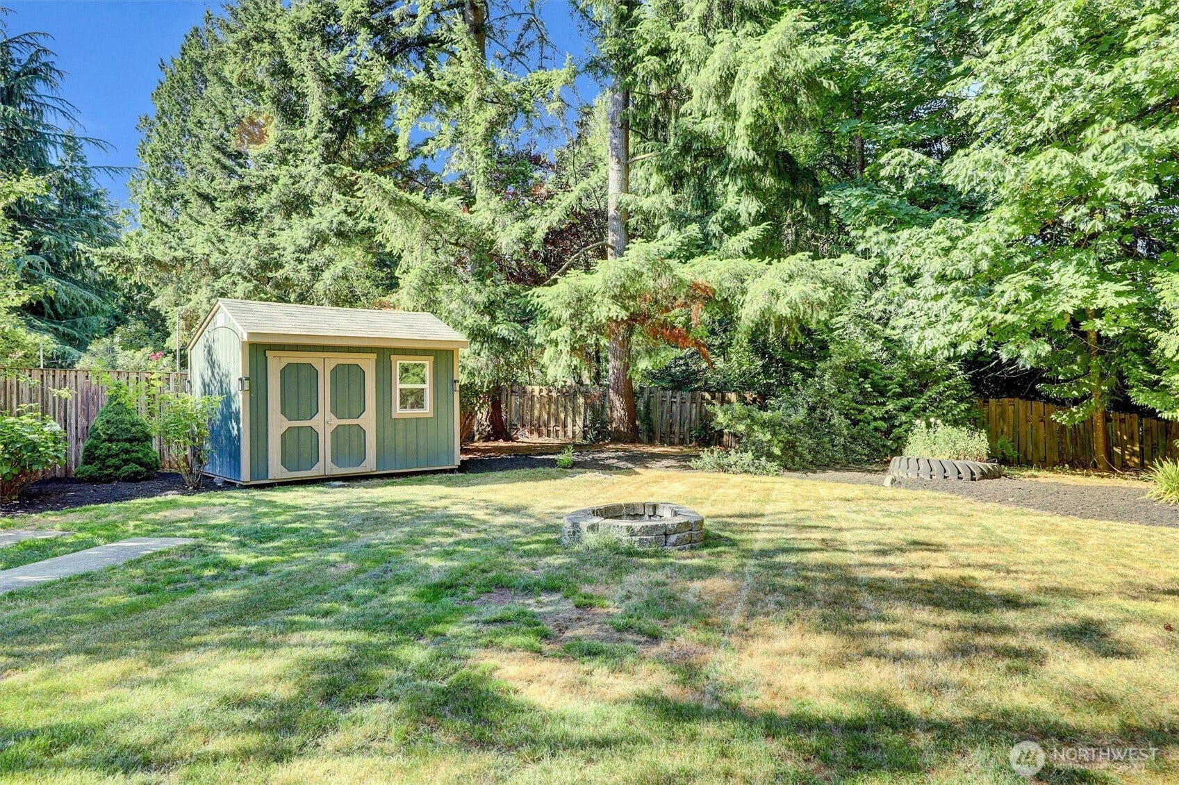 20915 W Richmond Road, Bothell, WA 98021 Spacious grassy backyard with a detached storage shed, mature trees, and a peaceful wooded setting.