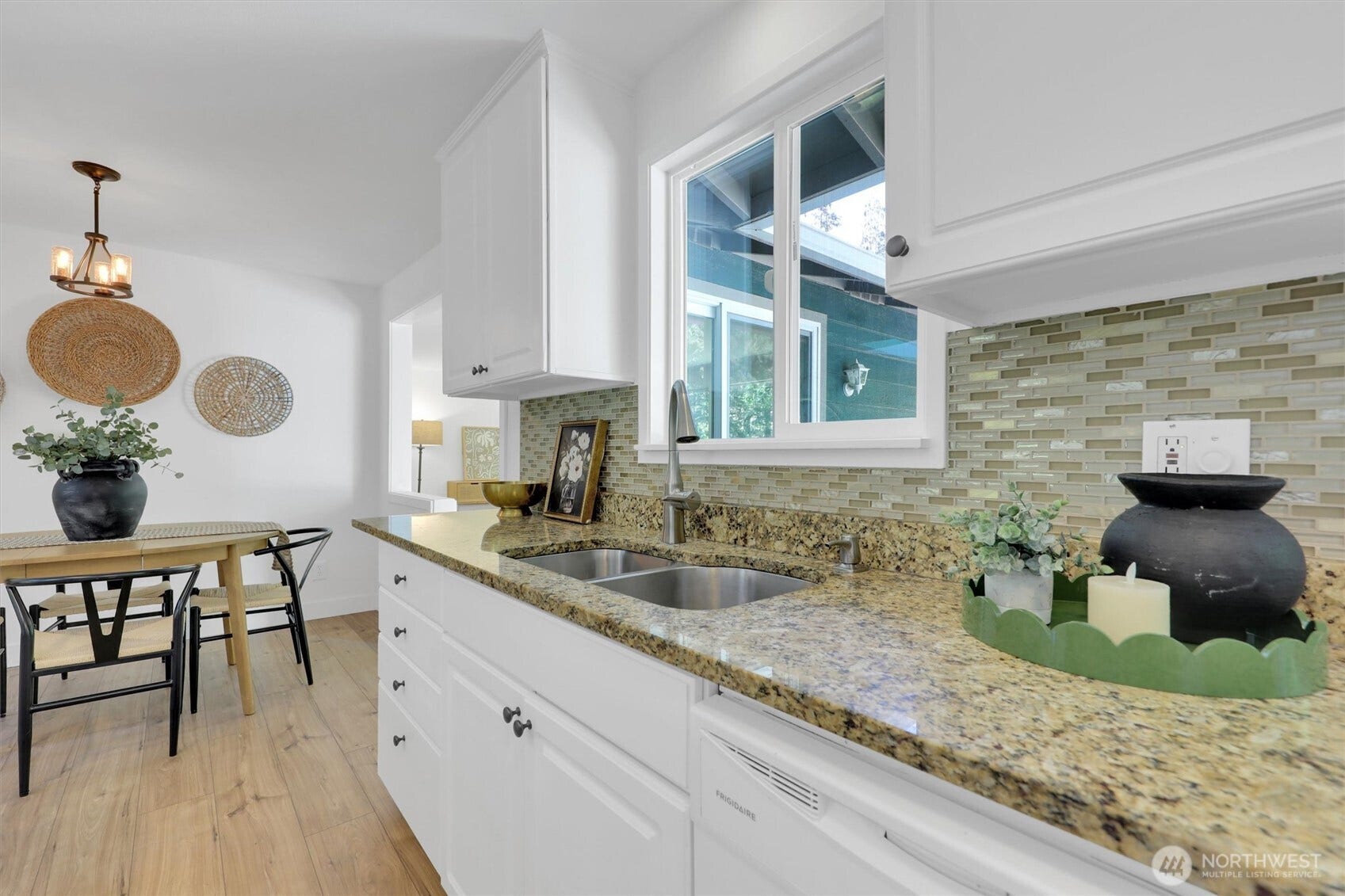 20915 W Richmond Road, Bothell, WA 98021 Detailed kitchen view highlighting granite countertops, white cabinetry, tiled backsplash, natural light, and adjacent dining area.