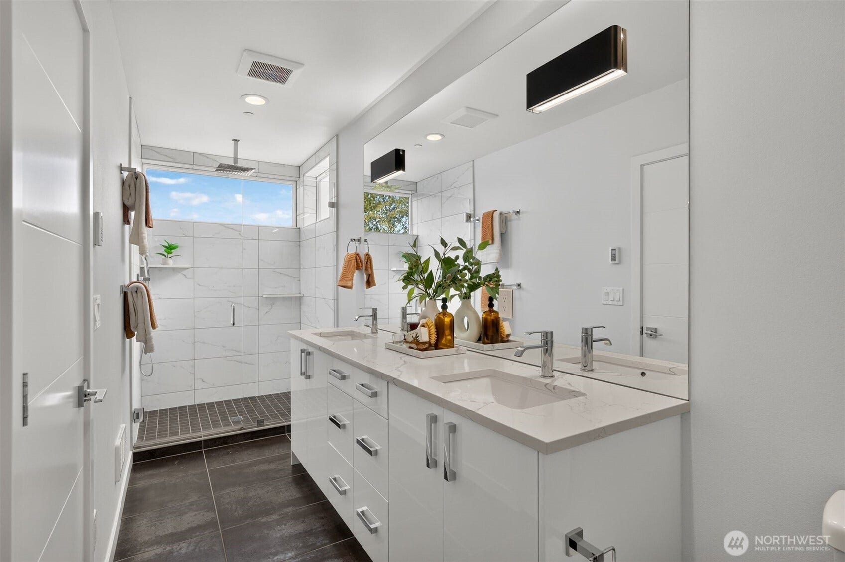 1615 S State Street, Seattle, WA 98144 The second-floor primary suite boasts a bathroom with two sinks, two sets of drawer banks, and a spacious shower with a rainhead and plenty of natural light streaming in from a large window. A true spa-like experience!