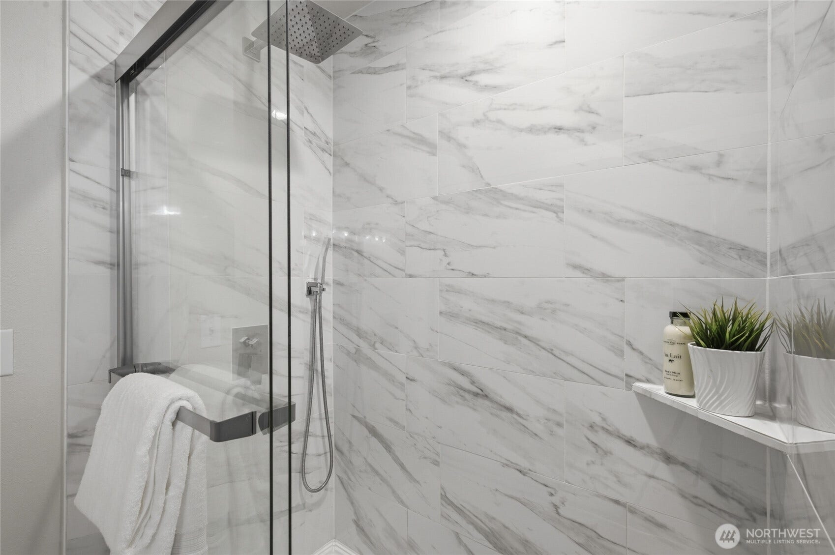 Tile wrapped large shower with dual shower heads create a luxurious experience.