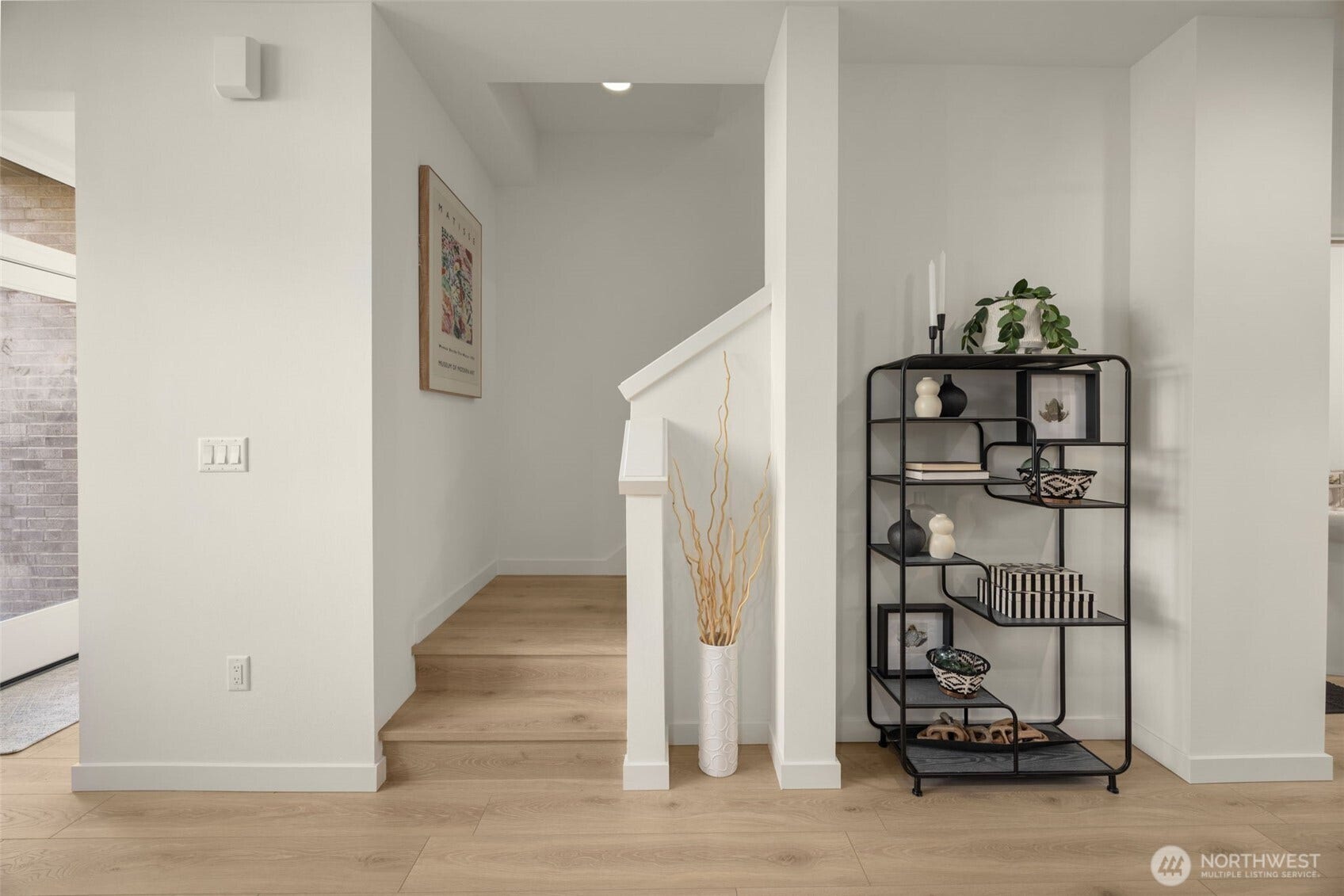 Entry with wide-plank floors and stair access