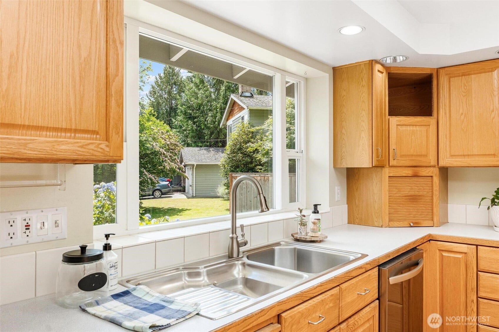 Large sink with shelf overlooking the front flower garden.