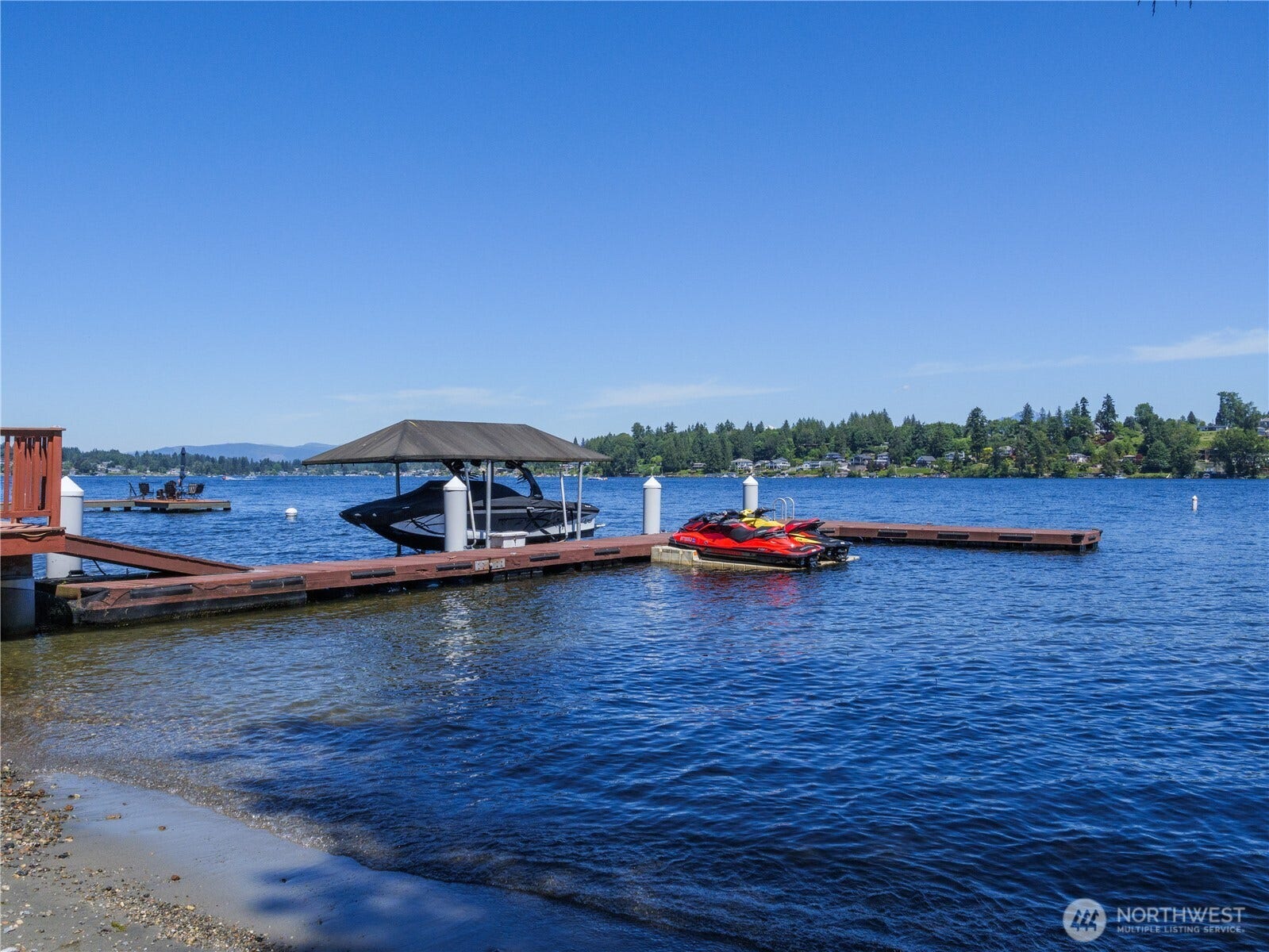 Private waterfront with dock, covered boat moorage, jet ski lifts, swimming area, and panoramic lake views.