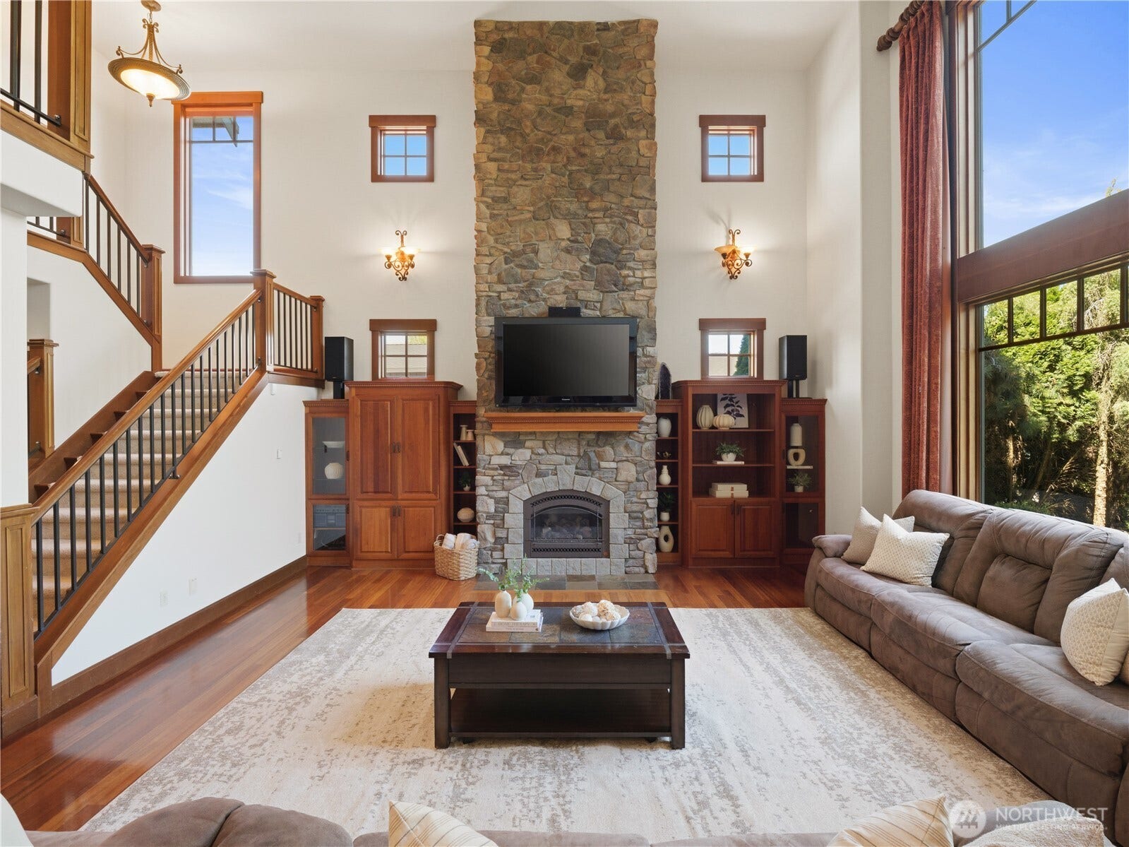 A stunning stone fireplace anchors the room, while custom built-ins, hardwood floors, and thoughtful architectural details add warmth and character.