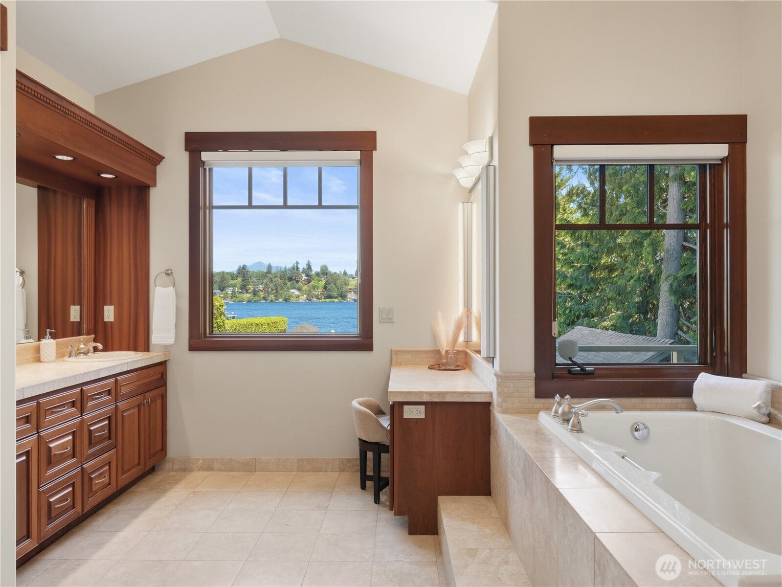 Enjoy water views from the comfort of the primary bath, featuring a soaking tub, dual-sink vanity, and abundant cabinetry.