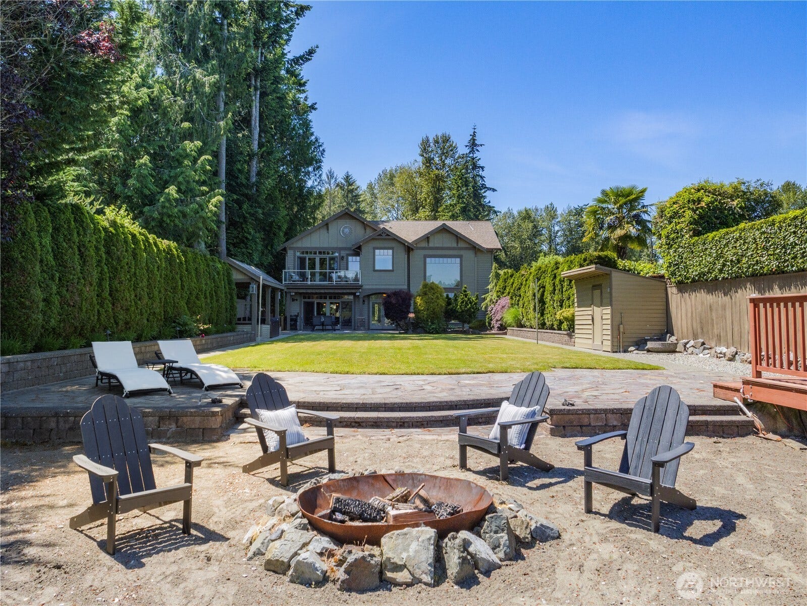 Gather around the fire pit, launch your watercraft from your own dock, or relax on the expansive lawn overlooking the lake. Framed by mature evergreens and designed to embrace its stunning setting, this property offers an exceptional blend of waterfront recreation, outdoor enjoyment, and scenic beauty.