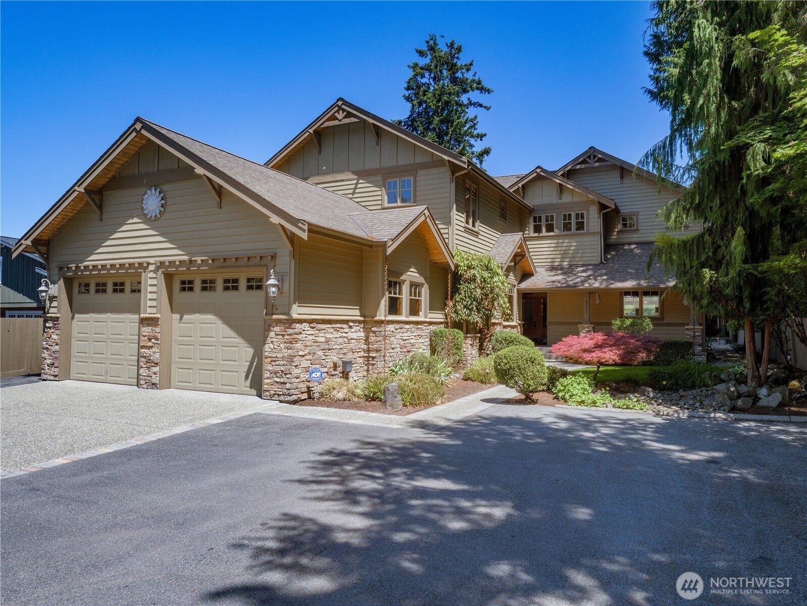 A striking Craftsman-inspired exterior with stone accents and beautifully maintained landscaping creates an unforgettable first impression, perfectly complementing this exceptional waterfront home.