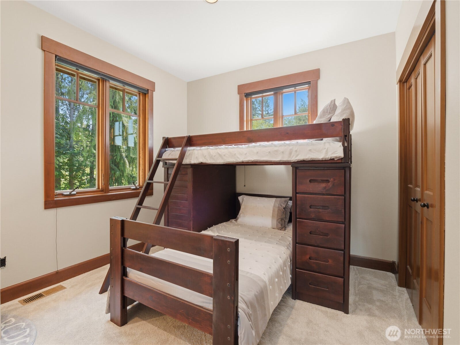 Spacious bedroom featuring extensive closet storage, large windows, and abundant natural light.