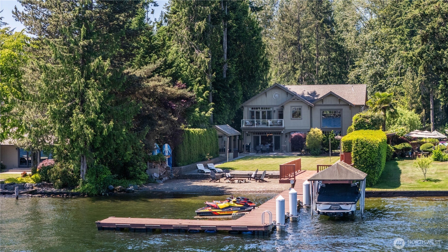 Every day features panoramic water views and spend your days enjoying the very best of lakefront living. This remarkable waterfront property features a private dock, covered boat moorage, shoreline beach area, and beautifully landscaped grounds that stretch to the water's edge.