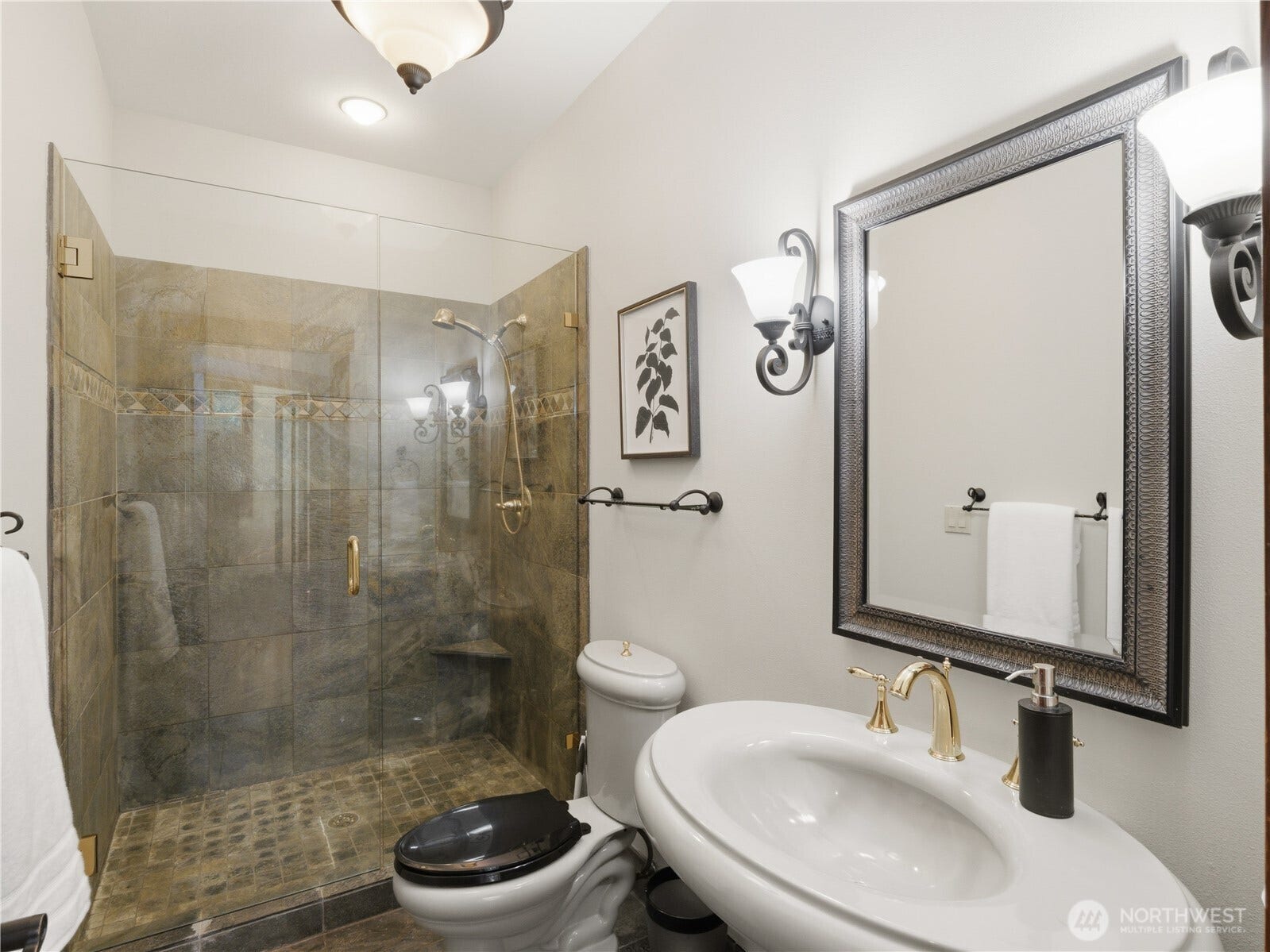 Designed with attention to detail, this bathroom features a walk-in tile shower with glass enclosure, elegant finishes, and refined fixture selections.
