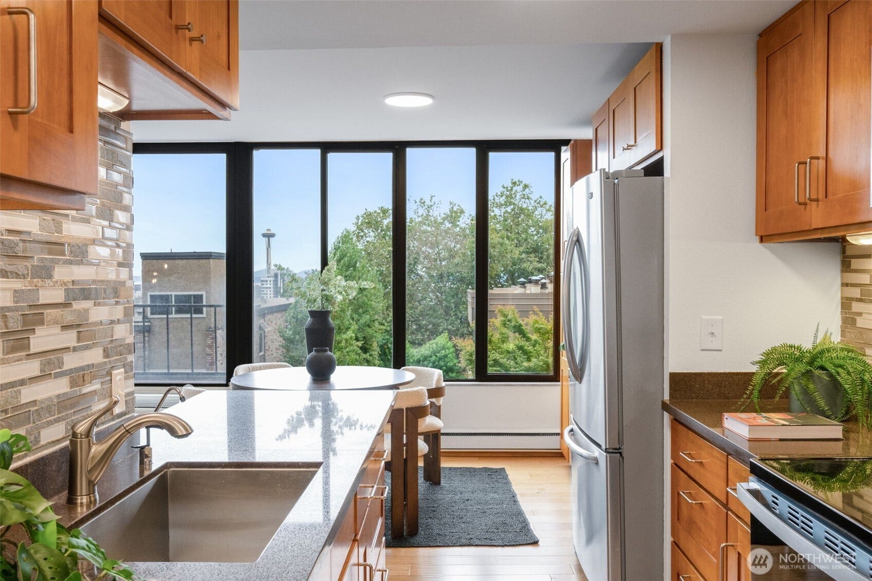 An open-concept kitchen featuring sleek granite slab countertops and upgraded appliances flows effortlessly into the dining area and spacious living room. The result is a beautifully connected space that blends comfort, style, and timeless elegance.