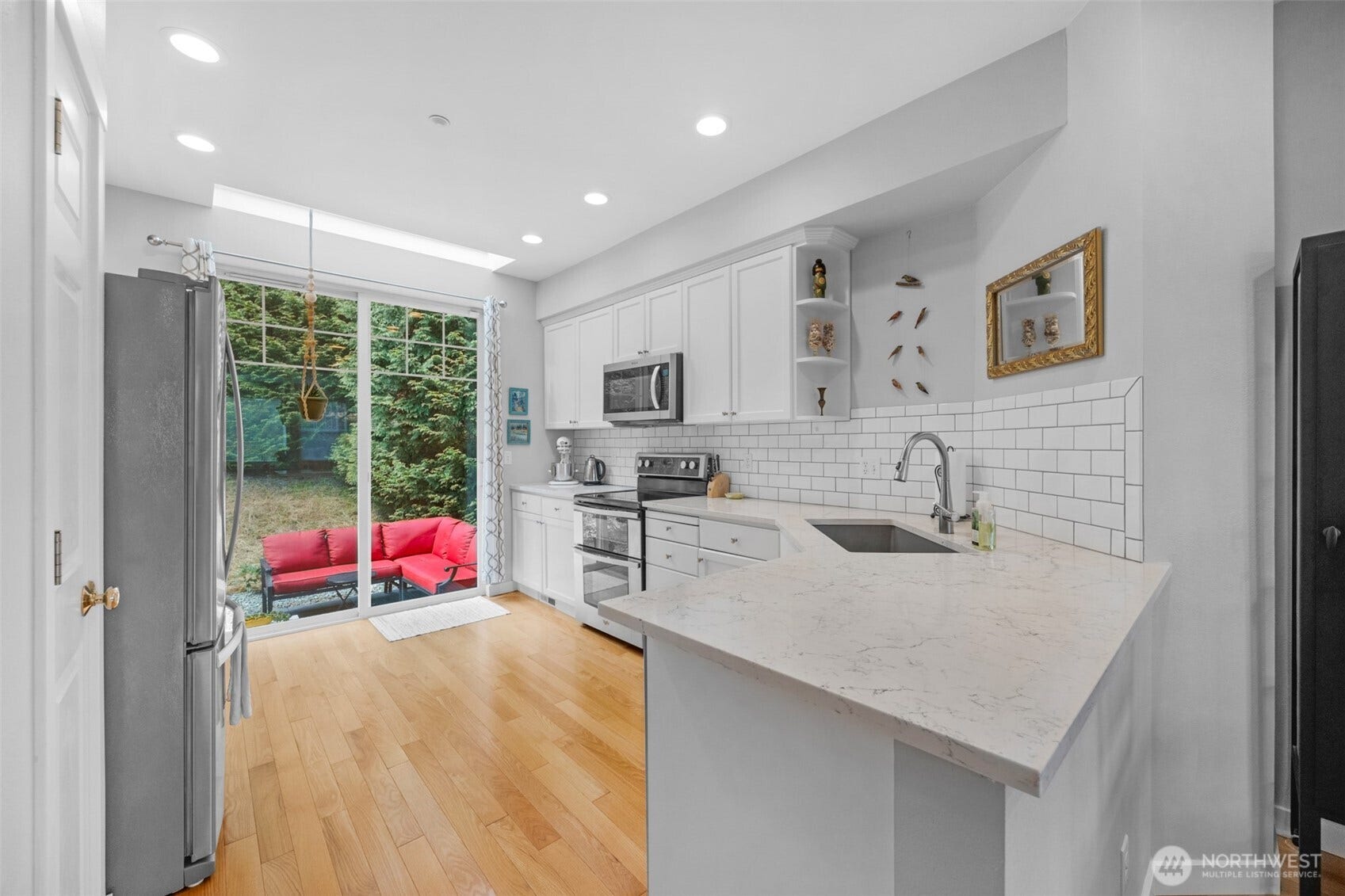 Bright, updated kitchen features gorgeous hardwood floors, SS appliances, quartz counters, pantry and skylight.