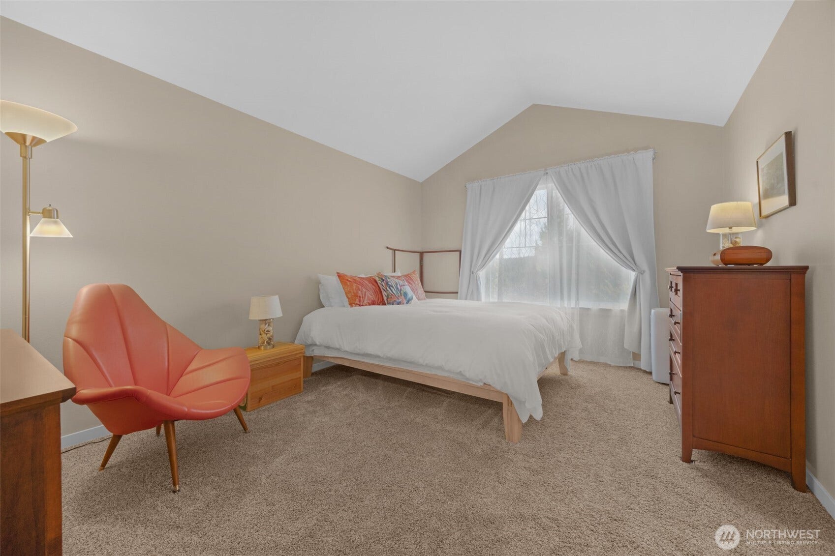 Spacious primary bedroom with vaulted ceilings.